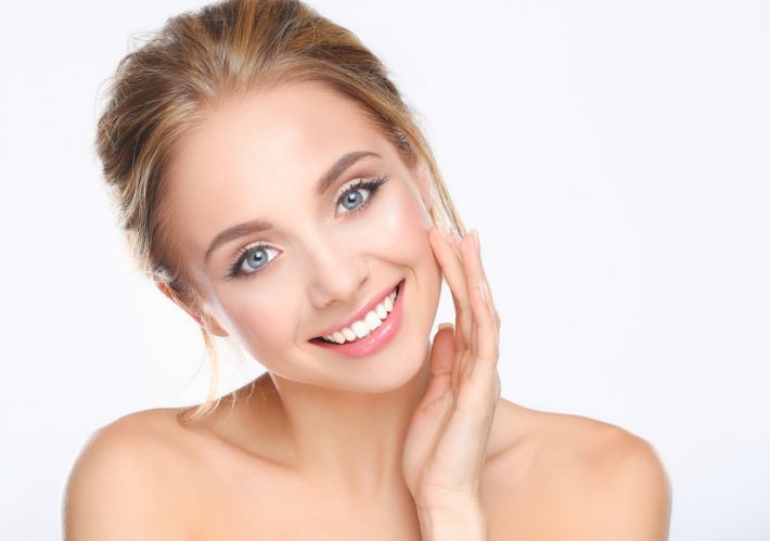 Young woman touching her face isolated on white background